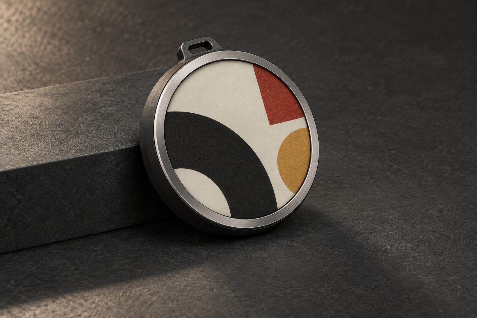 Circular e-paper badge design with colorful geometric artwork and a graphite enclosure